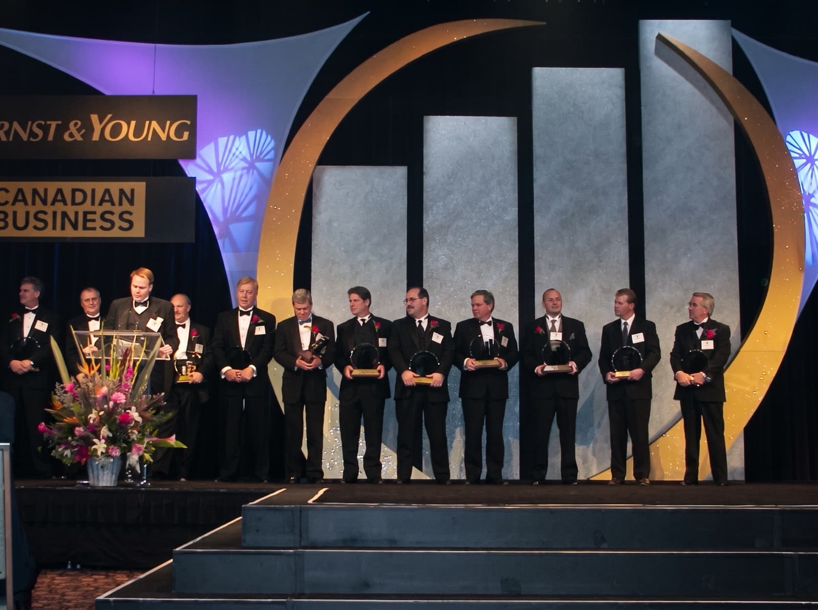 Award recipients line up on stage at the 2000 Ernst & Young Entrepreneur of the Year awards, each holding a crystal award